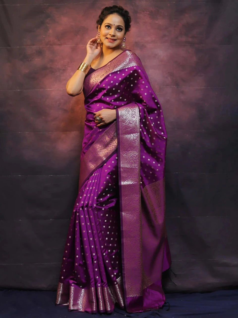 Woman wearing a purple saree with a dark background